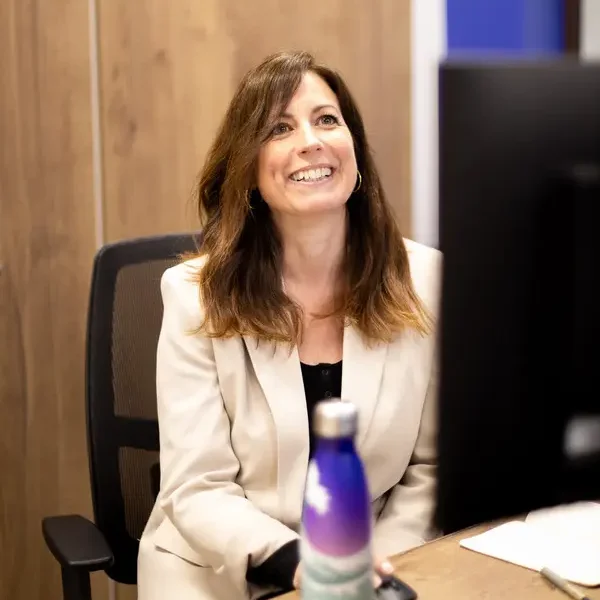 Kate sitting at her work desk with PMW branded bottle