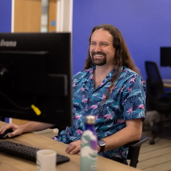 Photo of Alan sitting at his computer