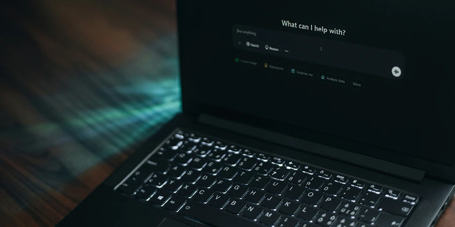 An open laptop on a wooden table, displaying an internet search page on the screen.