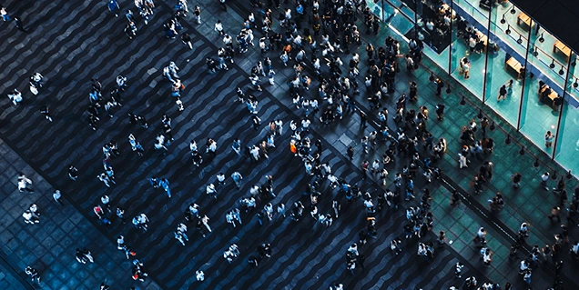 Looking down on a lot of people walking a long a street